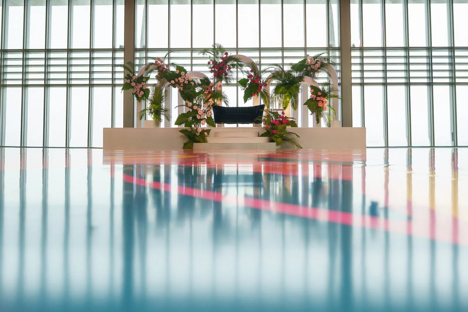 A reception stage set with floral arches at an Indian wedding