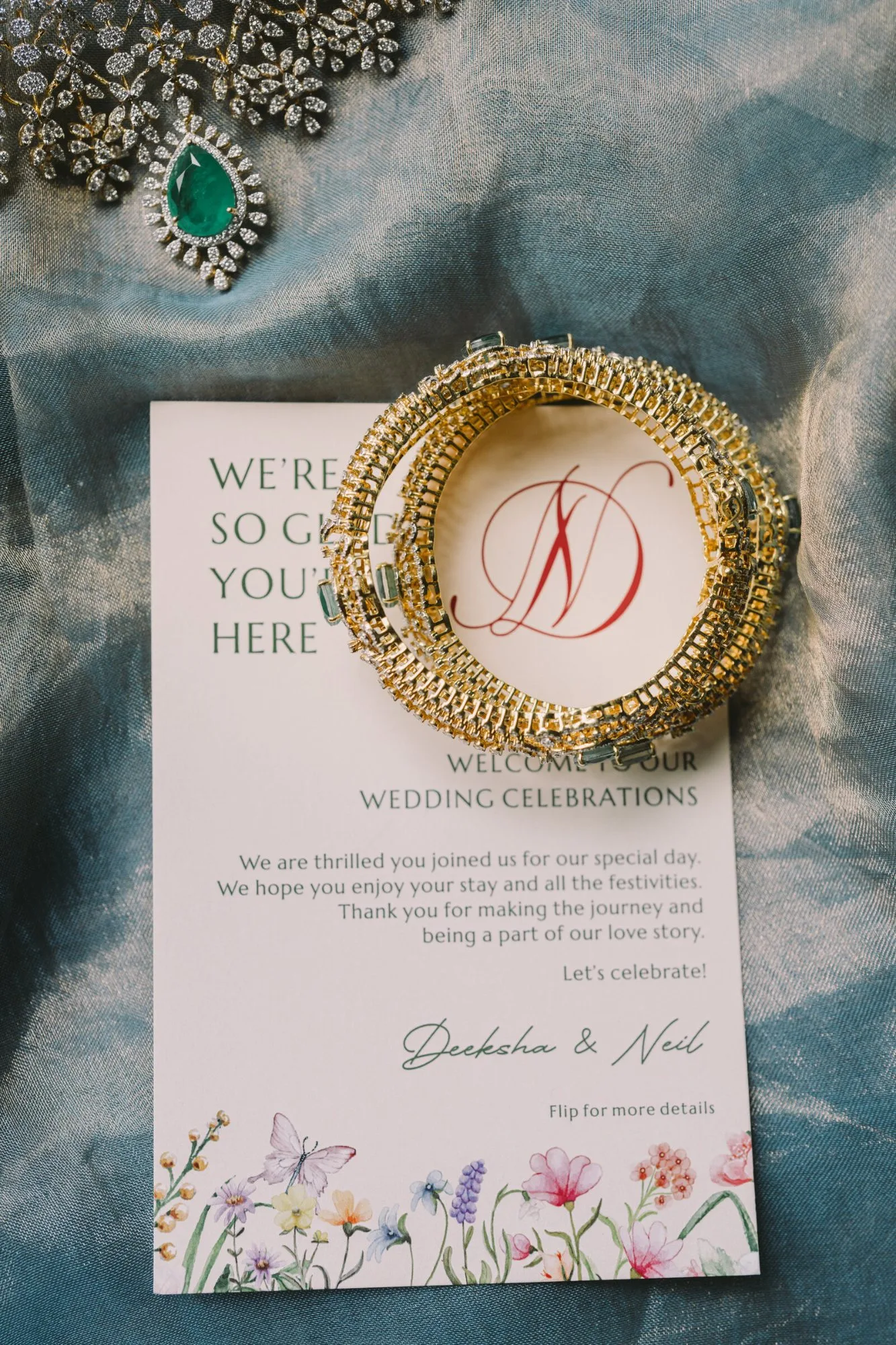 Bridal jewellery laid out before the ceremony — an emerald and diamond choker, bangles and embellished shoes